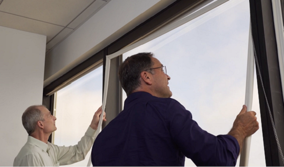 Two people with no equipment installing smart window inserts