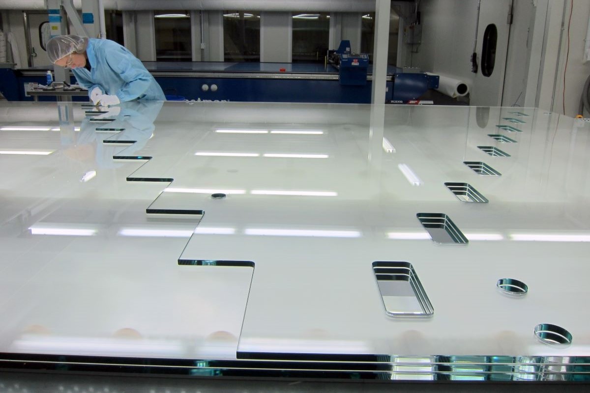 fabrication facility worker inspecting glass