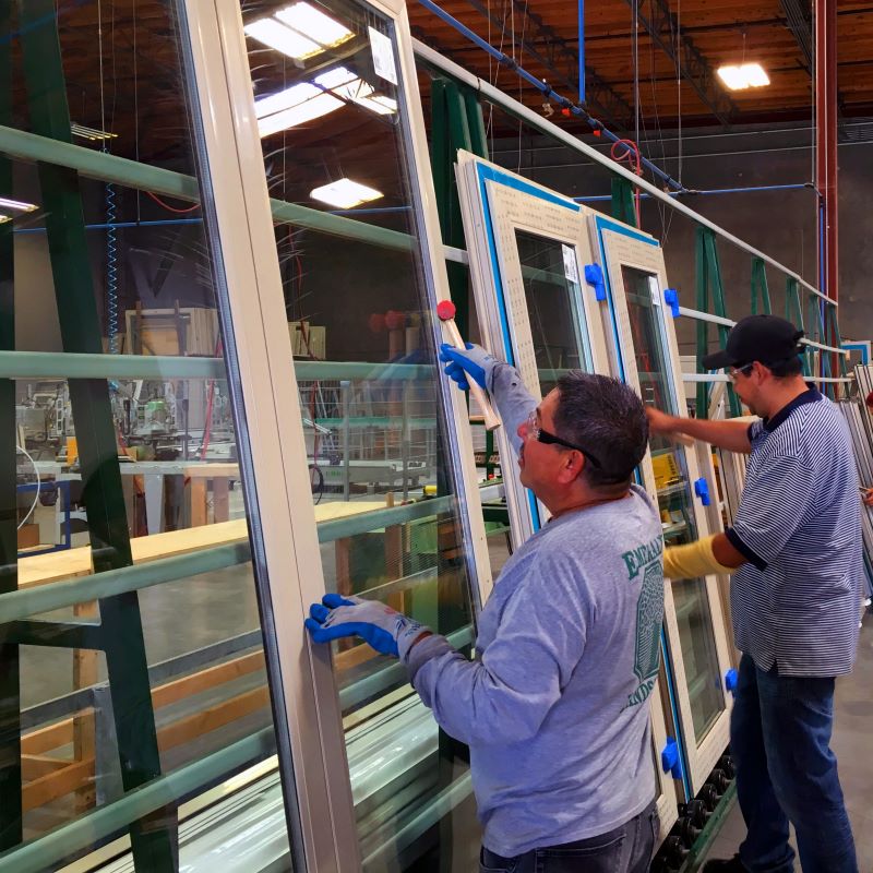 two factory workers on a fenestration line