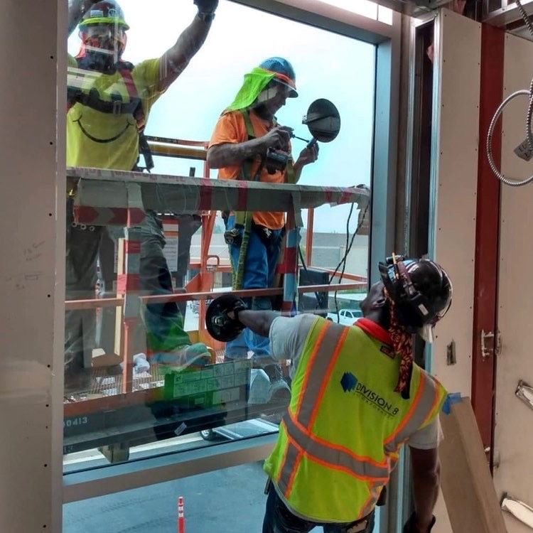 three glaziers install commercial glass