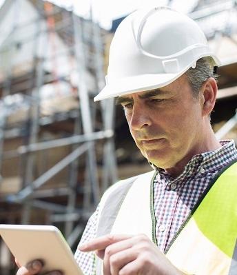 man on jobsite is reviewing information on phone