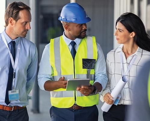 white man, black man and woman walk together on a job site