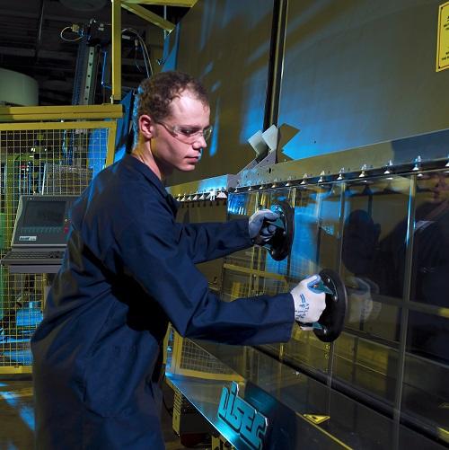 male worker adjusts a unit of glass on a manufacturing  line