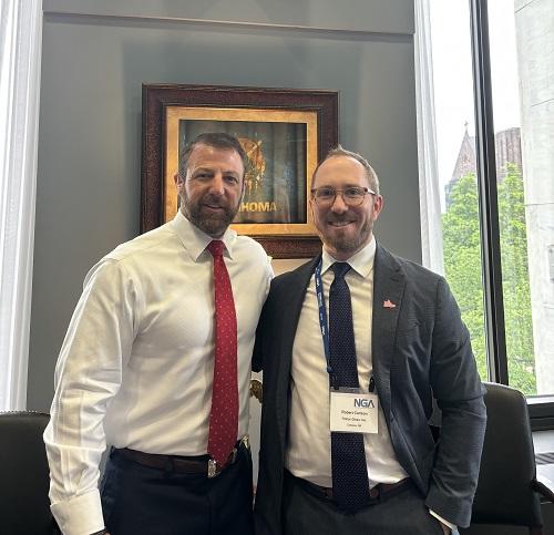 Rob Carlson and Markwayne Mullin stand together in front of an Oklahoma plaque